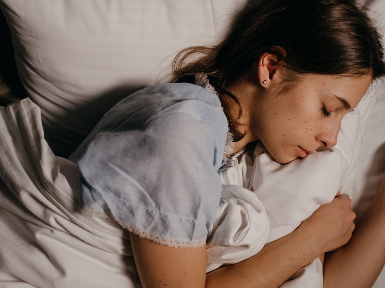 A young woman sleeping peacefully on a white pillow