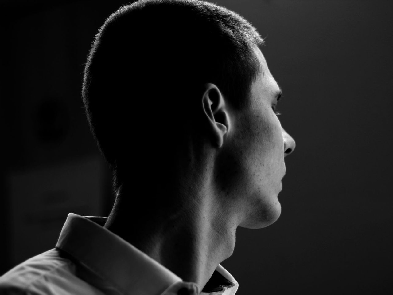 Black and white side profile of a man with short dark hair