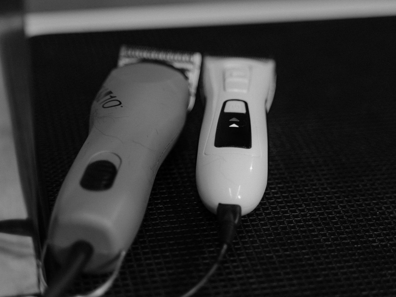 Black and white photo of two electric hair clippers