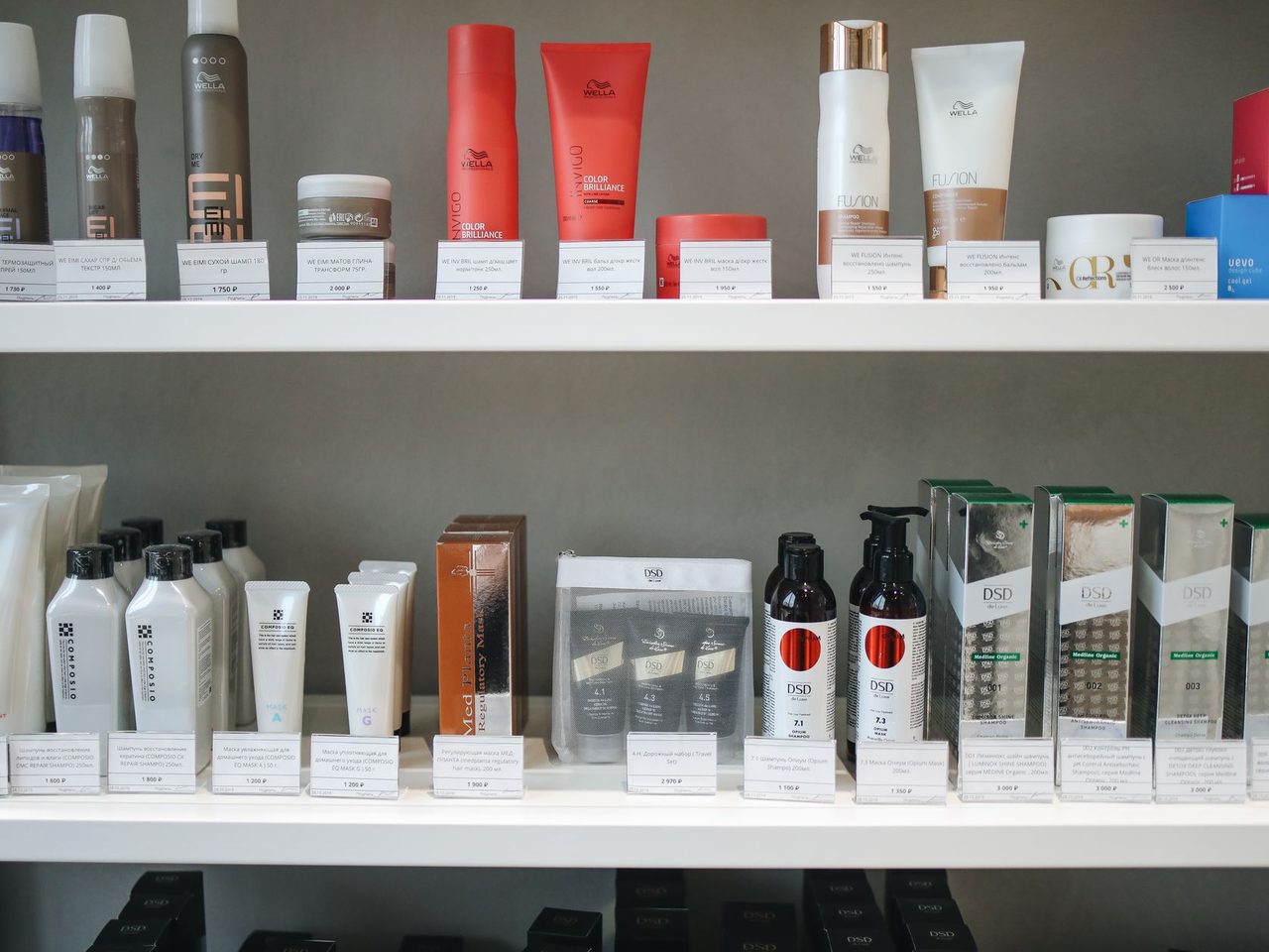 Rows of hair and skin care bottles and tubes neatly lined up on store shelves