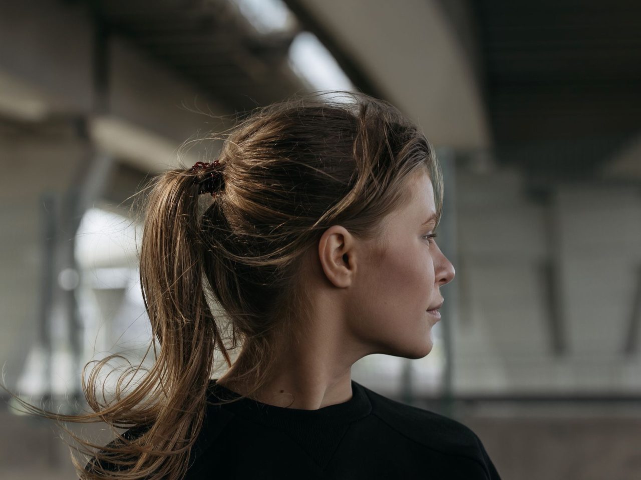 Side view of a woman with her hair pulled back into a high ponytail